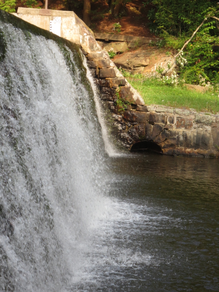 A peaceful image of a waterfall at a dam.